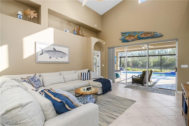 living room with high vaulted ceiling and light tile patterned floors