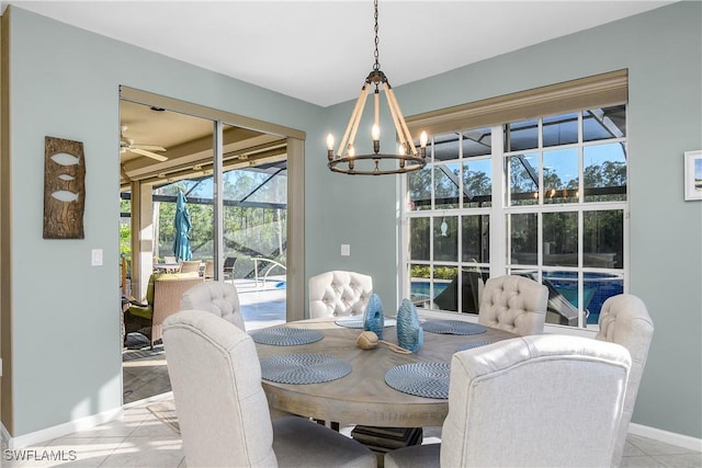 dining space with ceiling fan with notable chandelier and light tile patterned floors