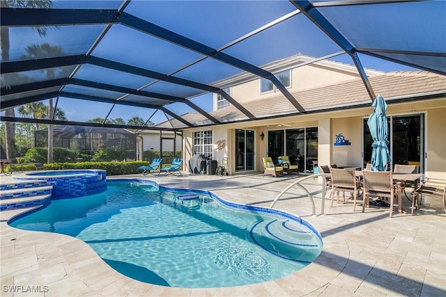 view of pool featuring an in ground hot tub, glass enclosure, and a patio area