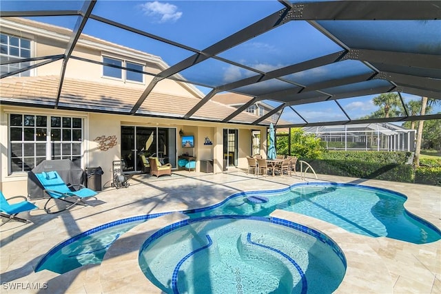 view of swimming pool featuring an in ground hot tub, a patio, and glass enclosure