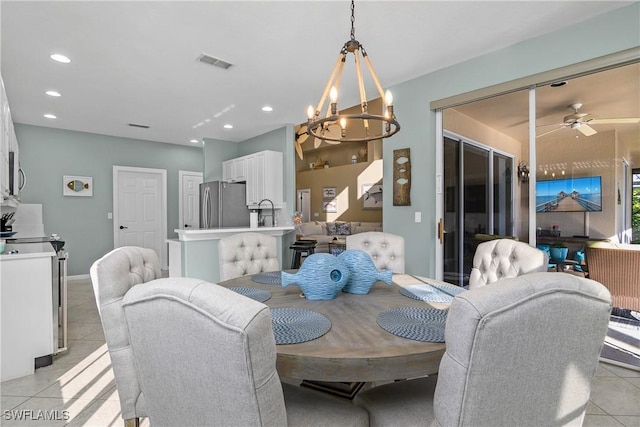 dining room featuring ceiling fan with notable chandelier, sink, and light tile patterned floors