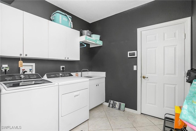 washroom with cabinets, sink, washer and dryer, and light tile patterned flooring