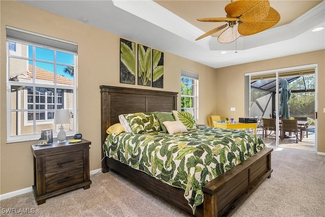 carpeted bedroom with crown molding, a tray ceiling, access to outside, and ceiling fan