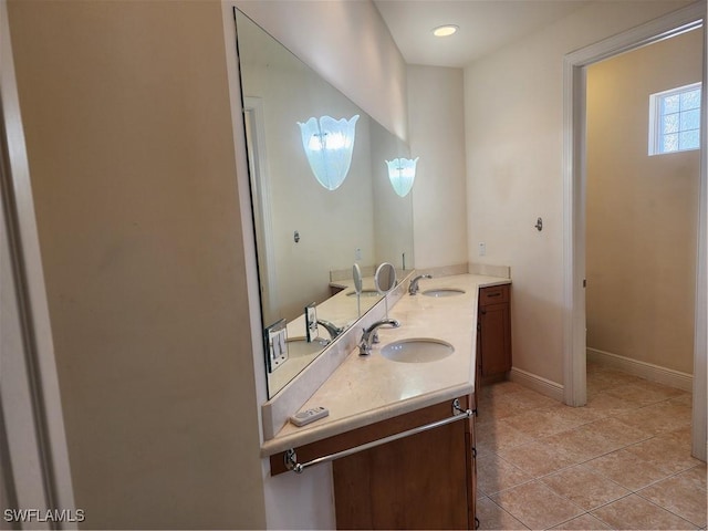 full bathroom featuring double vanity, tile patterned flooring, baseboards, and a sink