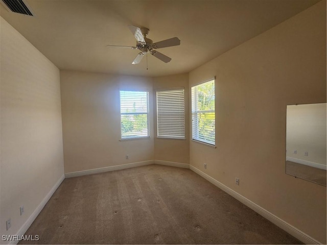 spare room with carpet flooring, baseboards, visible vents, and ceiling fan