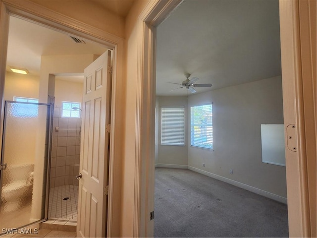 hallway with visible vents, carpet, and baseboards