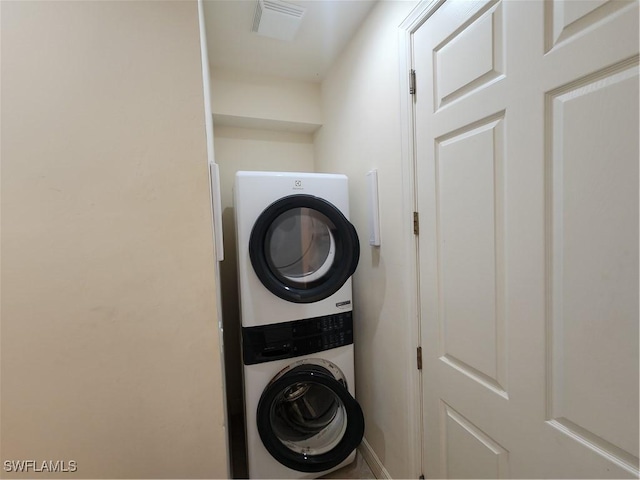 laundry room featuring stacked washer / dryer, laundry area, and visible vents