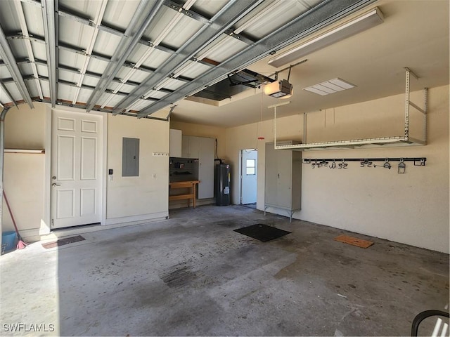 garage featuring water heater, a garage door opener, and electric panel