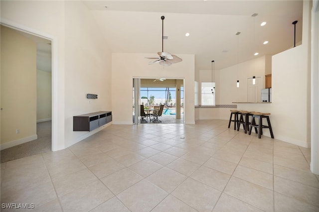 10347 Wood Ibis Ave, Bonita Springs, FL 34135 - unfurnished living room with a high ceiling, light tile patterned floors, a ceiling fan, and recessed lighting