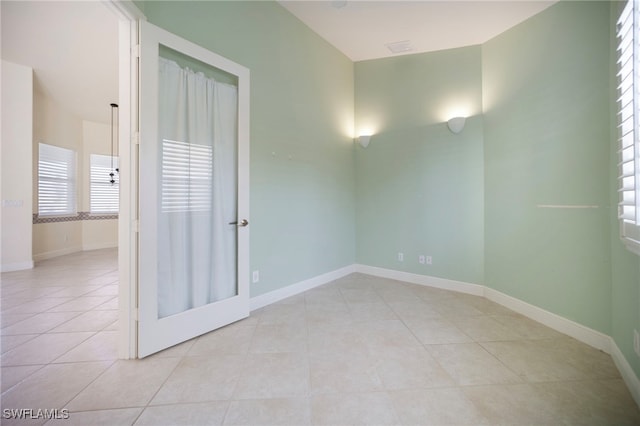 10347 Wood Ibis Ave, Bonita Springs, FL 34135 - spare room with light tile patterned floors, a healthy amount of sunlight, and baseboards
