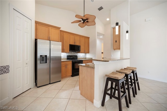 10347 Wood Ibis Ave, Bonita Springs, FL 34135 - kitchen with black appliances, light stone counters, a ceiling fan, and light tile patterned floors