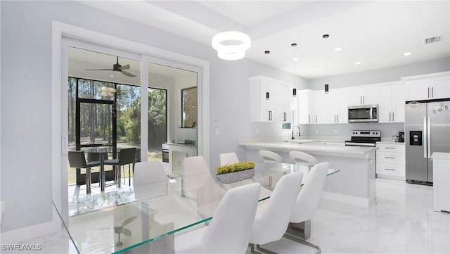 dining room featuring ceiling fan and sink