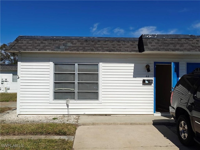 exterior space featuring roof with shingles