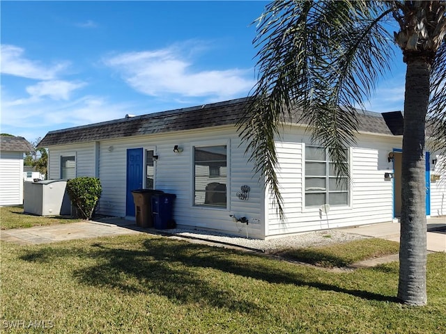 single story home with a shingled roof and a front yard