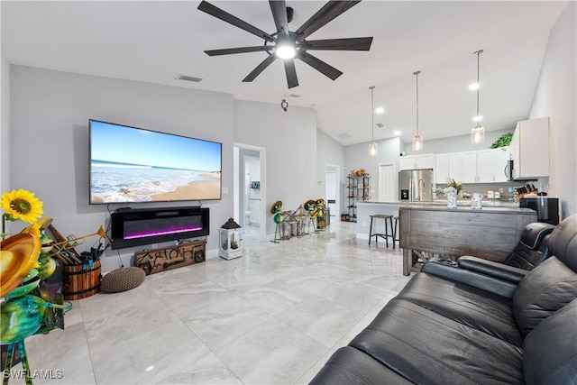 living room with ceiling fan and high vaulted ceiling