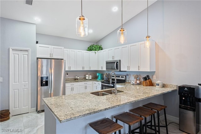 kitchen with a breakfast bar, white cabinetry, hanging light fixtures, kitchen peninsula, and stainless steel appliances