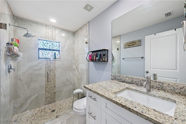 bathroom featuring vanity, tile patterned flooring, toilet, and walk in shower