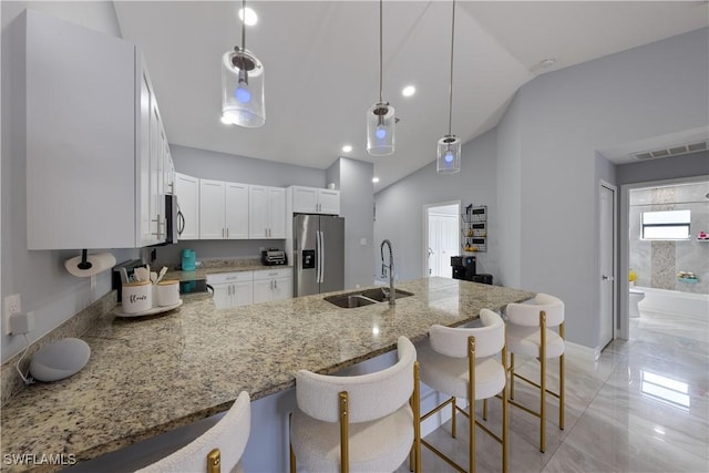 kitchen with sink, decorative light fixtures, kitchen peninsula, stainless steel appliances, and white cabinets