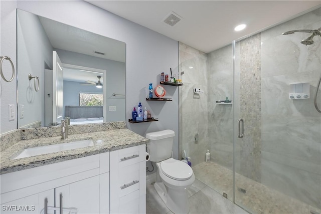 bathroom featuring vanity, ceiling fan, a shower with shower door, and toilet