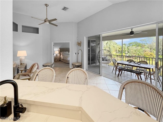 dining area with lofted ceiling, light tile patterned floors, and ceiling fan