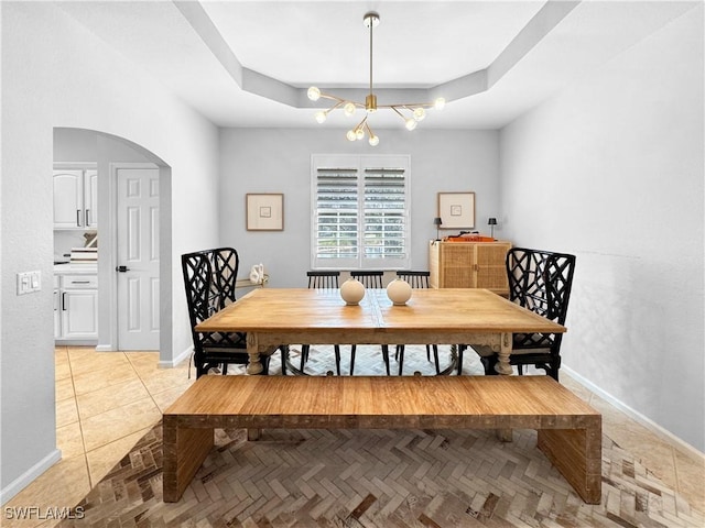 tiled dining space with a tray ceiling