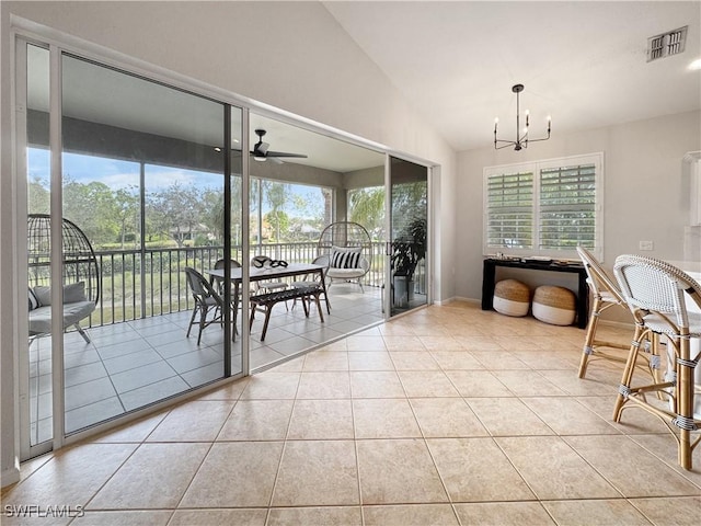 tiled dining space with lofted ceiling and ceiling fan with notable chandelier