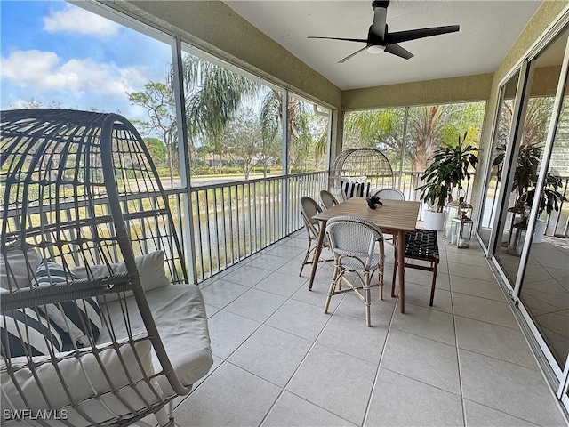 sunroom / solarium featuring a water view, a healthy amount of sunlight, and ceiling fan