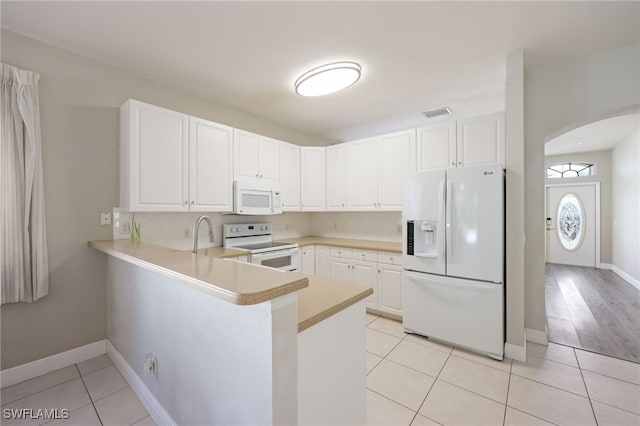 kitchen featuring white cabinetry, light tile patterned floors, white appliances, and kitchen peninsula