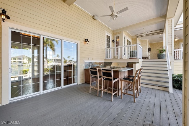 wooden deck with ceiling fan and an outdoor bar