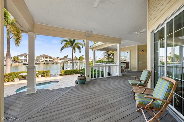 wooden terrace with ceiling fan and a water view