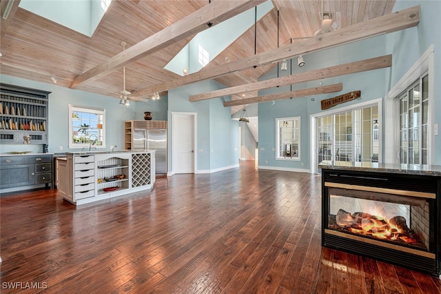 living room with beam ceiling, a skylight, and dark wood-type flooring