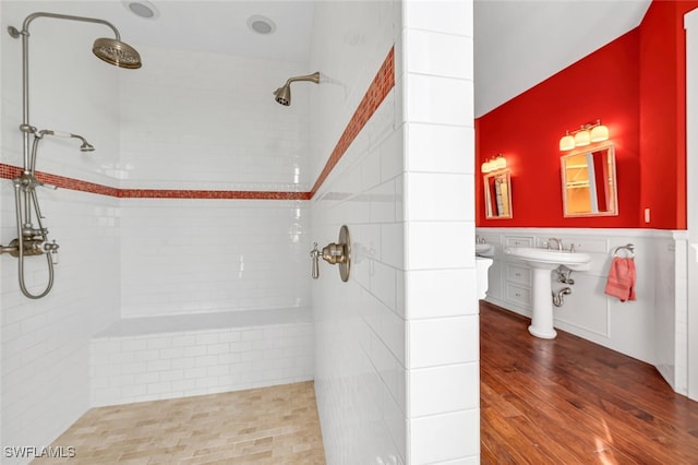 bathroom with wood-type flooring and a tile shower