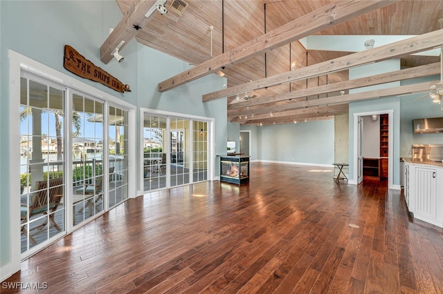 unfurnished living room featuring ceiling fan, high vaulted ceiling, dark wood-type flooring, and beam ceiling