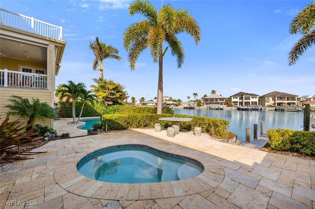 view of pool featuring a water view, an in ground hot tub, and a patio