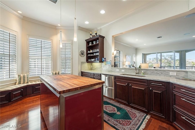 kitchen featuring sink, wooden counters, tasteful backsplash, a kitchen island, and dark hardwood / wood-style flooring