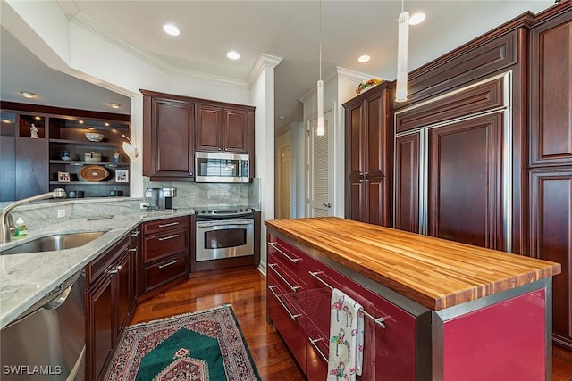 kitchen with stainless steel appliances, a center island, sink, and wooden counters