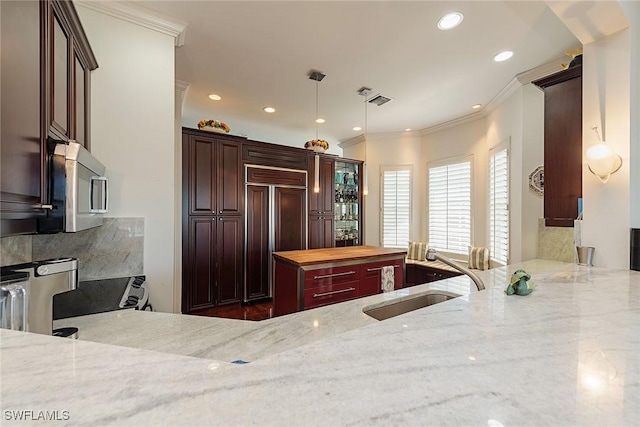 kitchen with sink, wooden counters, hanging light fixtures, crown molding, and paneled refrigerator