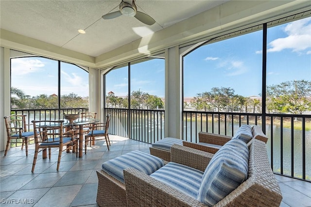 sunroom / solarium with a water view and ceiling fan