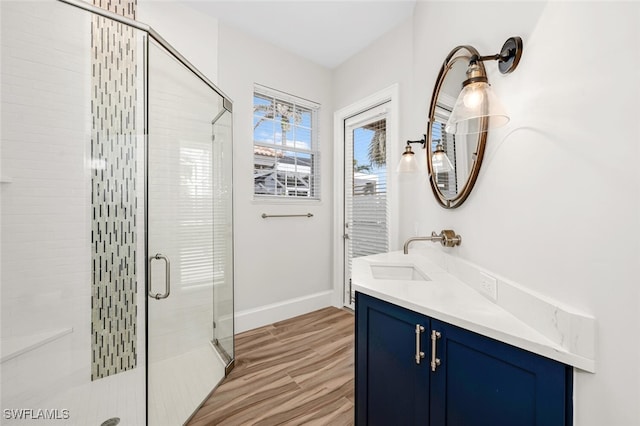 bathroom with vanity, hardwood / wood-style flooring, and a shower with door