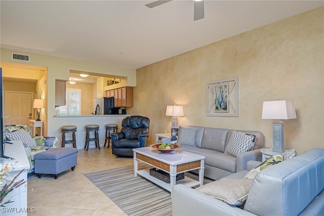 tiled living room with ceiling fan