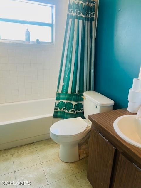 full bathroom featuring tile patterned floors, toilet, shower / tub combo, and vanity