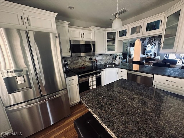 kitchen featuring pendant lighting, sink, white cabinetry, stainless steel appliances, and dark hardwood / wood-style flooring