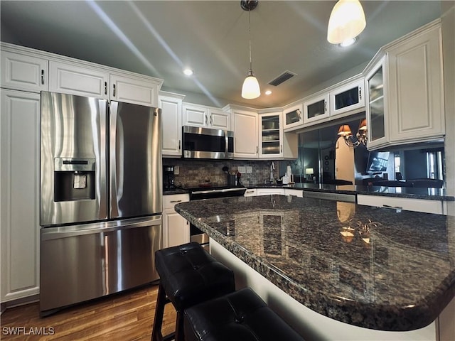 kitchen with white cabinetry, appliances with stainless steel finishes, dark hardwood / wood-style floors, and pendant lighting