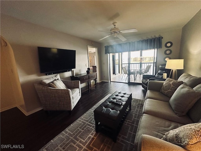 living room with dark wood-type flooring and ceiling fan