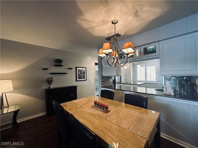 dining room with dark hardwood / wood-style flooring and an inviting chandelier