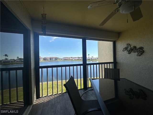 sunroom with a water view and ceiling fan