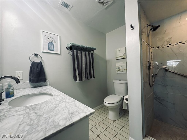 bathroom featuring tiled shower, vanity, toilet, and tile patterned flooring