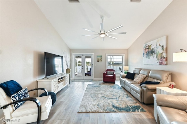 living room featuring french doors, ceiling fan, vaulted ceiling, and light hardwood / wood-style floors