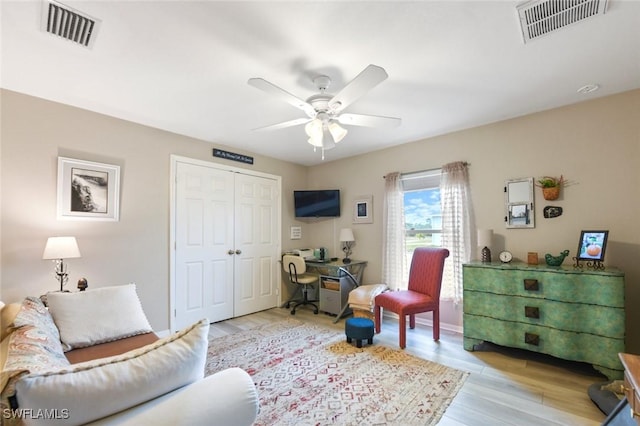 living room with ceiling fan and light wood-type flooring