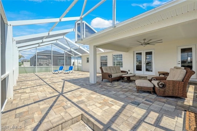 view of patio / terrace featuring an outdoor living space, ceiling fan, glass enclosure, and french doors